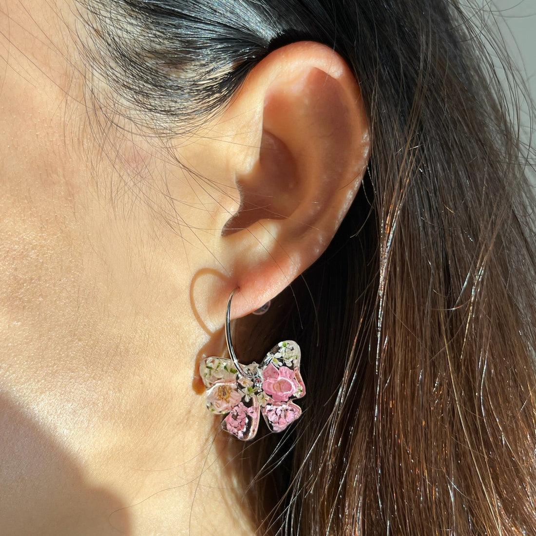 bow-shaped resin earrings with real dried flowers encased inside.