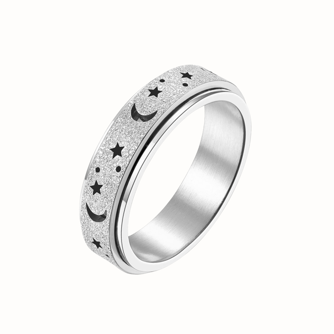 A gold-toned stainless steel spinner ring with star and moon engravings, photographed on a clean white background.