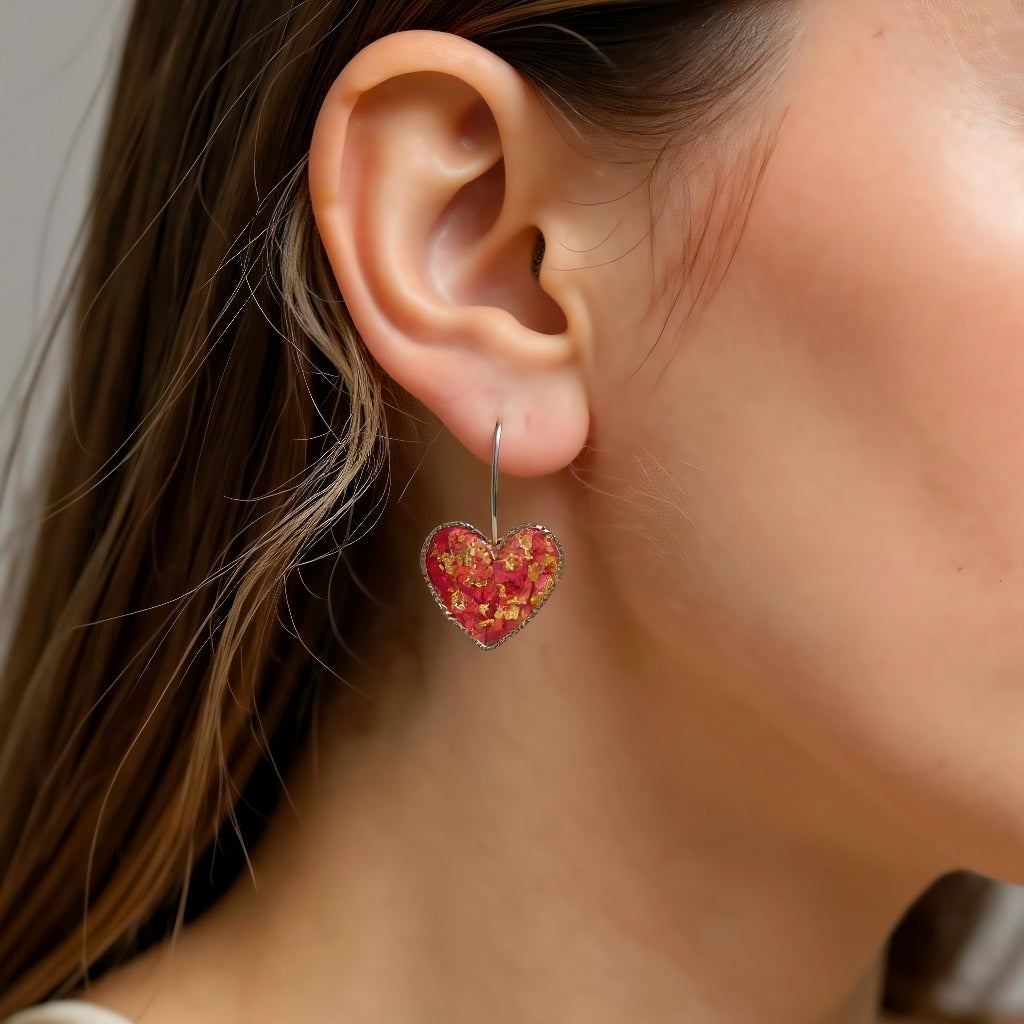 Close-up of a person wearing a red heart-shaped earring.