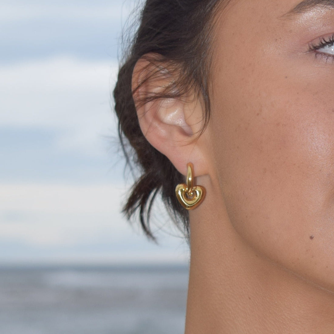 Detachable puffed heart huggie earrings in silver.