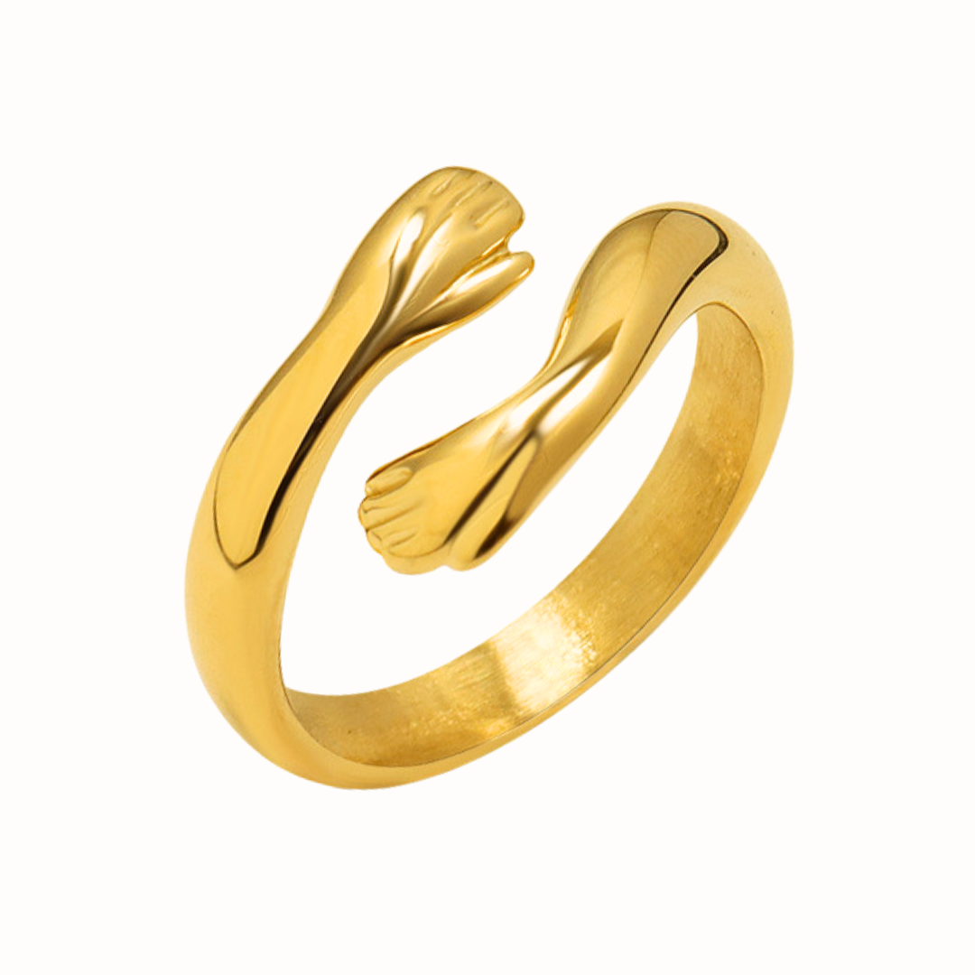 Gold ring with a design of hugging hands on a white background