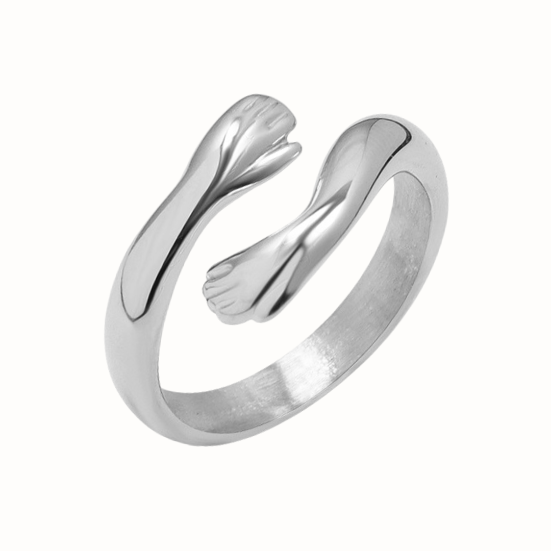 Silver ring with a design of hugging hands on a white background