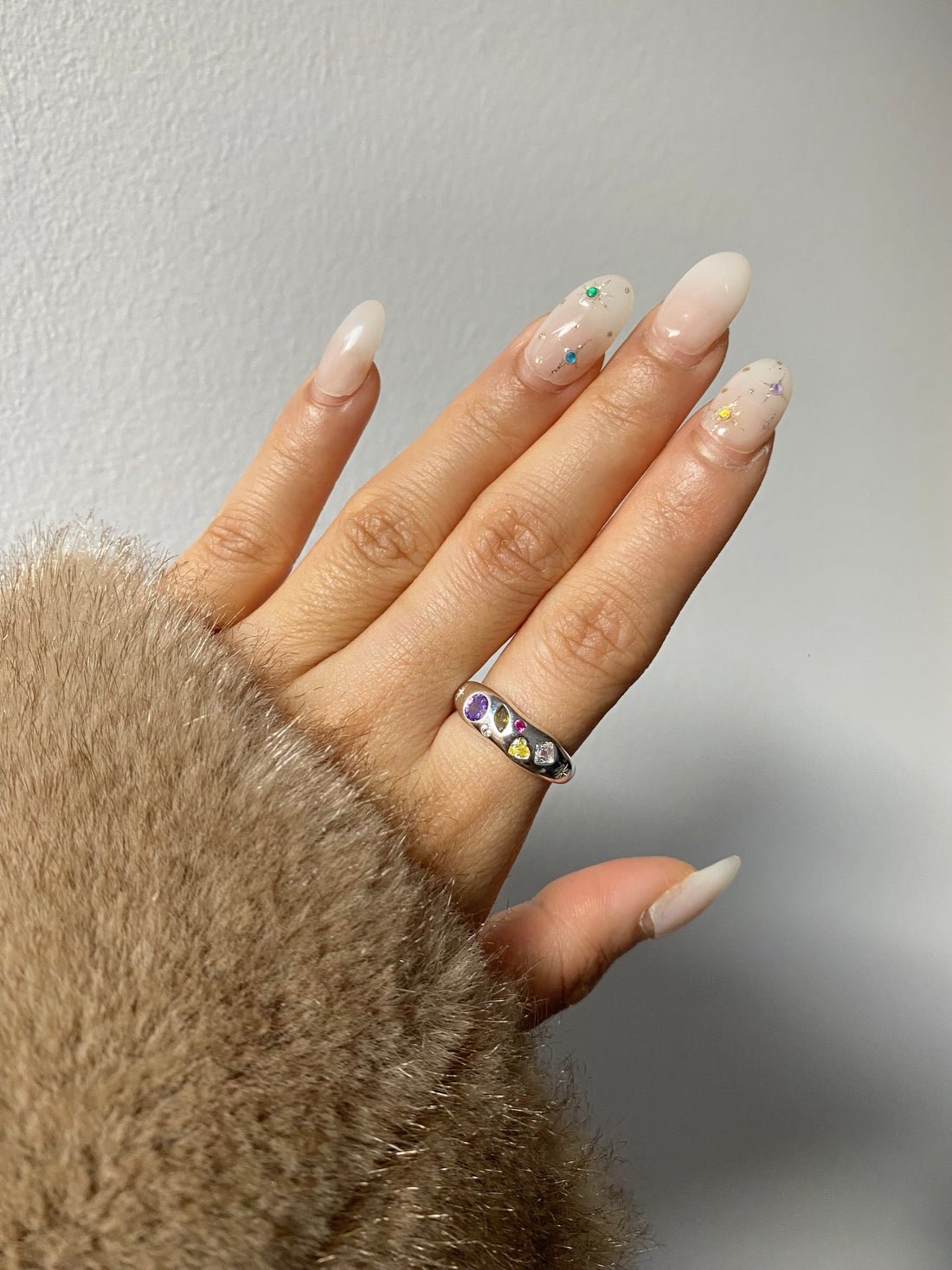 Sterling silver adjustable ring with rainbow cubic zirconia stones.