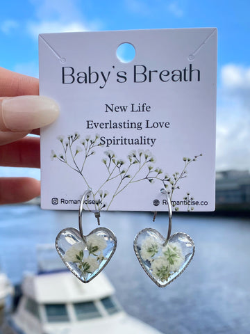 Peach-heart resin earrings with white baby's breath inside stainless steel frame.