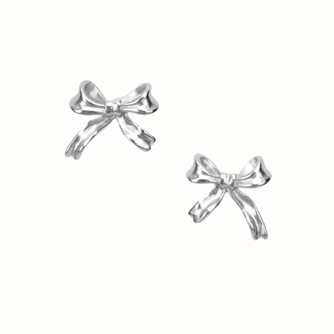 Close-up of dainty sterling silver bow stud earrings.