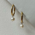 Gold freshwater pearl clip-on hoops.