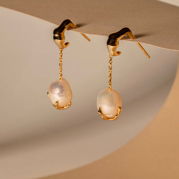 Close-up of golden baroque pearl drop earrings made from 18ct gold-plated sterling silver.