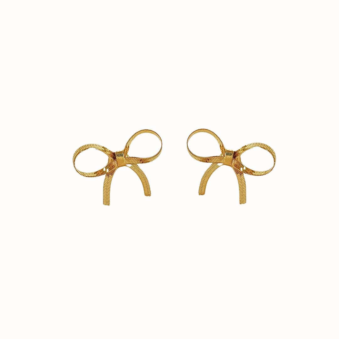 A pair of gold Mini Dancing Ribbon Earrings with a bow design, displayed on a white background.