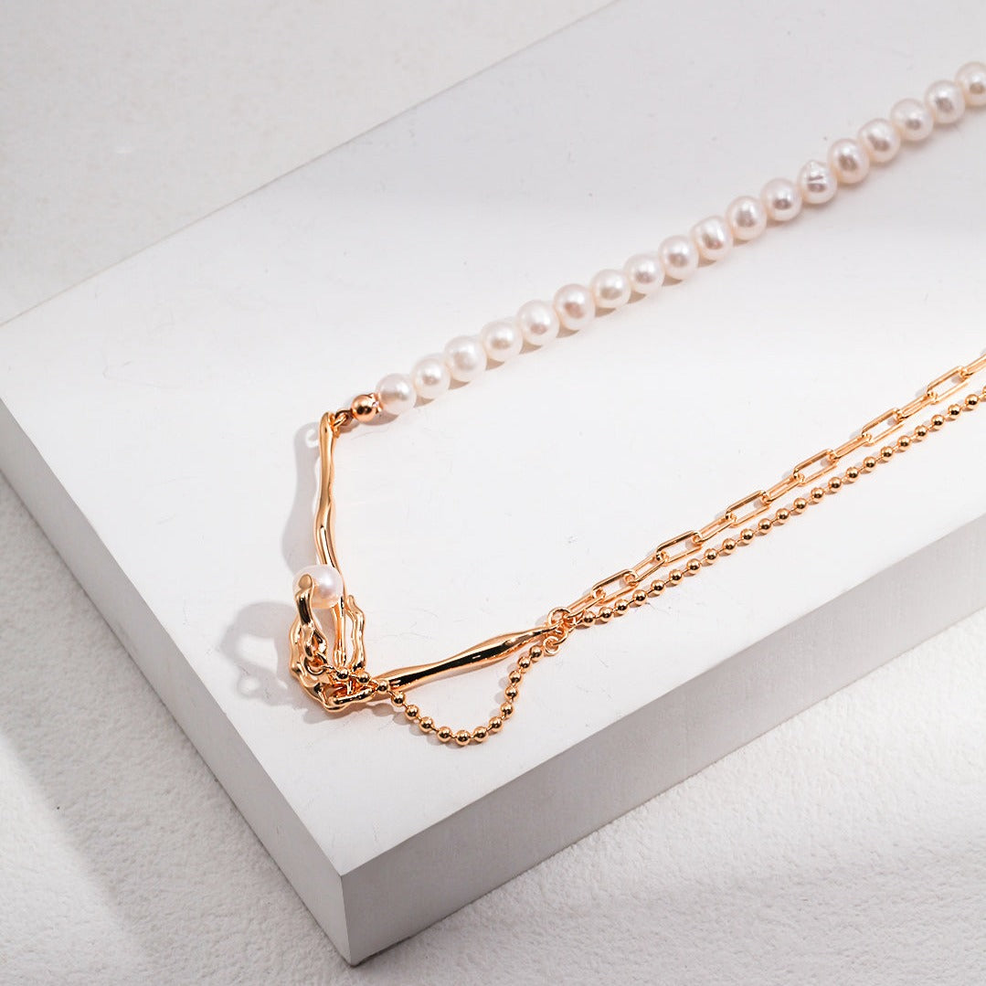 Asymmetrical pearl necklace with a nest-shaped pendant and lustrous pearl centre.
