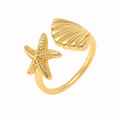 A gold Ocean Girl Adjustable Ring, featuring a starfish and shell design, placed on a clean white background.