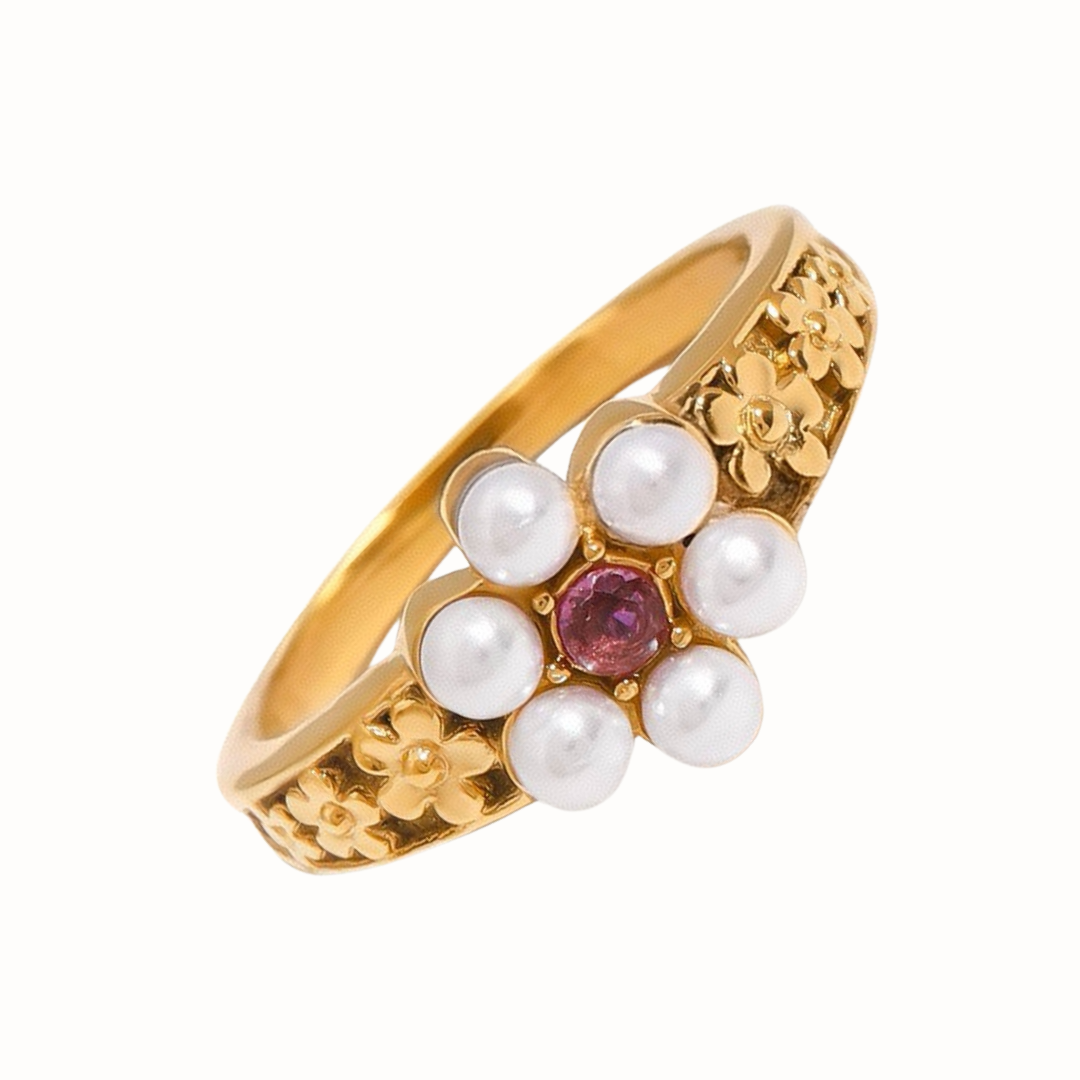 A gold-tone floral ring featuring freshwater pearls and a pink cubic zirconia center, photographed against a white background.