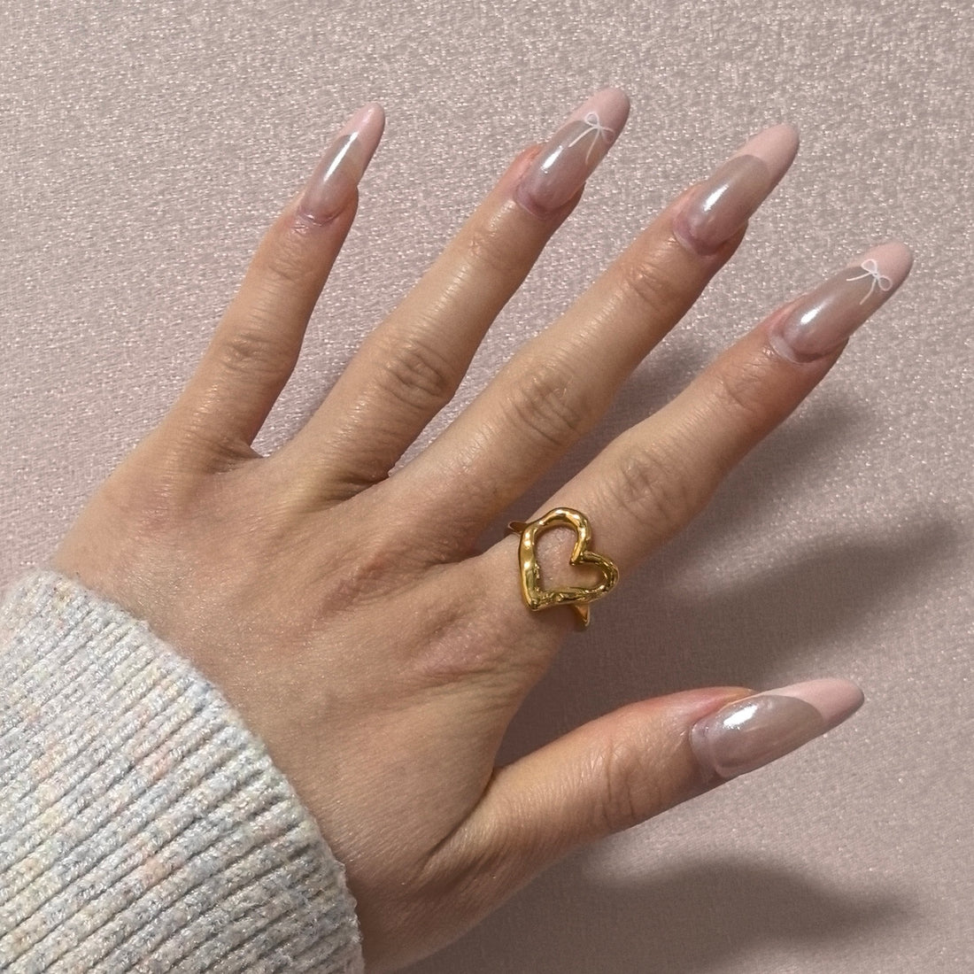 A hollow heart-shaped stainless steel ring in gold, displayed on a white background.