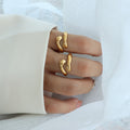 Gold rings on a person's fingers with a white background