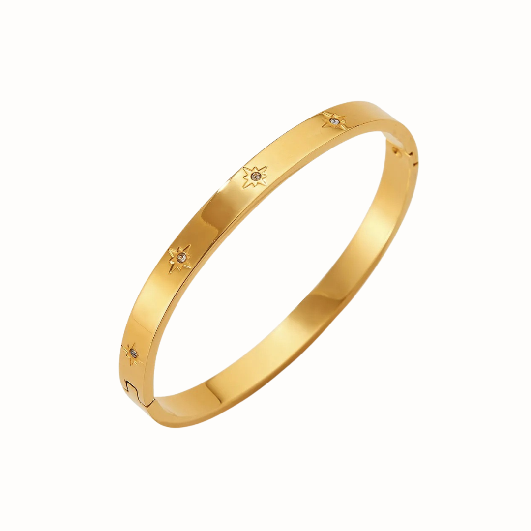 Gold-tone stainless steel starburst bangle bracelet with cubic zirconia.