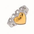 stainless steel ring with a silver strap-style band and a gold heart centerpiece, on a clean white studio background with bright lighting.
