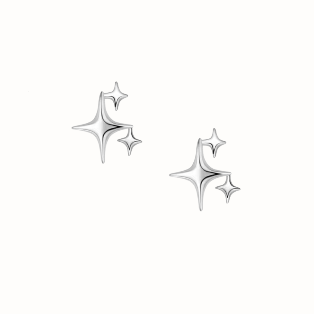 Close-up of dainty triple star stud earrings in sterling silver.